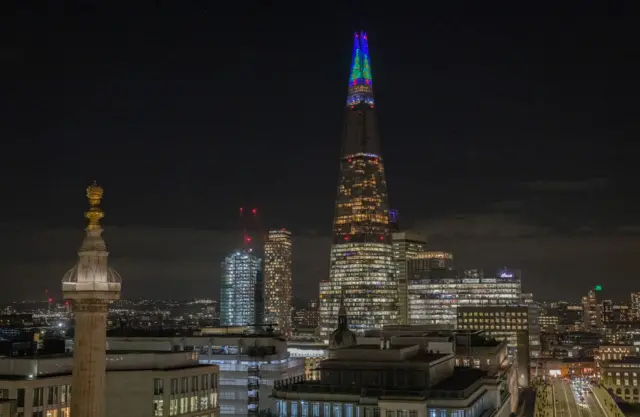 The Shard iluminada con luces que forman la figura de un árbol de navidad.
