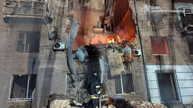 Strażak pracuje w miejscu, gdzie budynek mieszkalny został trafiony rosyjskim pociskiem rakietowym, podczas rosyjskiego ataku na Ukrainę, w Krzywym Rogu w obwodzie dniepropietrowskim w Ukrainie