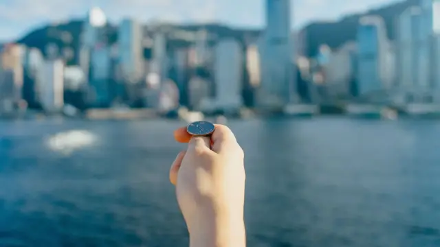 يد تمسك عملة معدنية