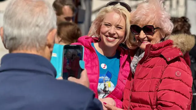 Urška Klakočar Župančič (levo) sa pristalicom se drži za ruke tokom fotografisanja