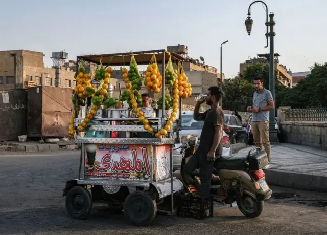 A motorcyclist enjoys a fresh fruit juice in the Gamaliya district of Egyptian capital, Cairo, on Saturday.