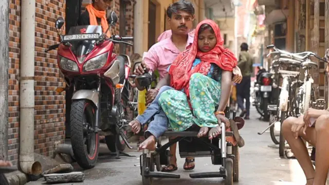 వీల్ ఛైర్‌ మీద ఇద్దరు వ్యక్తులు