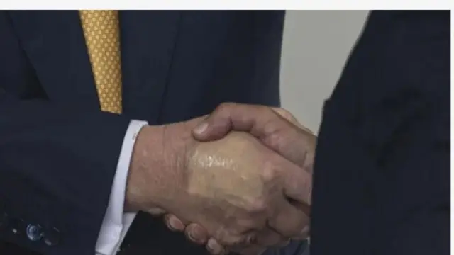 Aworan ọwọ meji to n ki ara wọn, ọkan ninu awọn ọwọ naa fi apẹẹrẹ ailera han