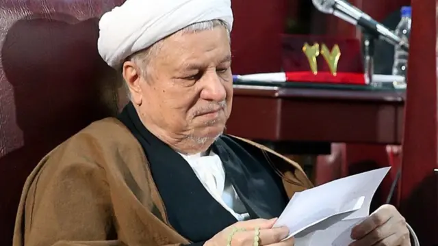 هاشمی رفسنجانی در حال خواندن یک برگه