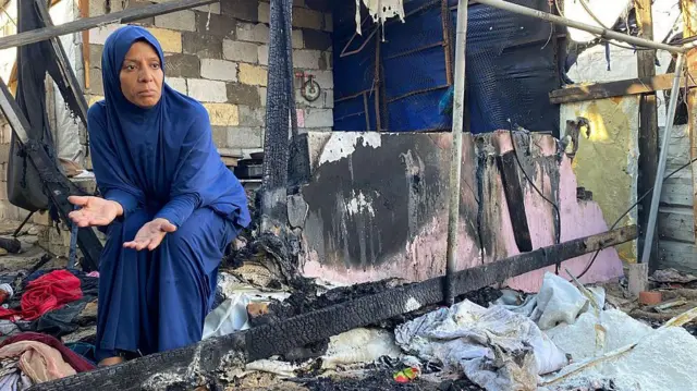 Женщина сидит у развалин своего дома после израильского удара по окрестностям Хан-Юниса