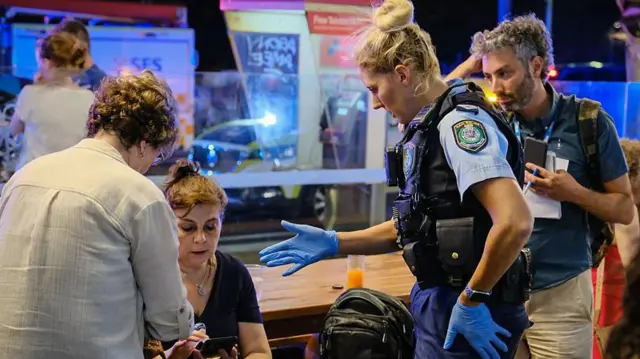 La policía habla con miembros del público en la escena del tiroteo en Bondi Beach.