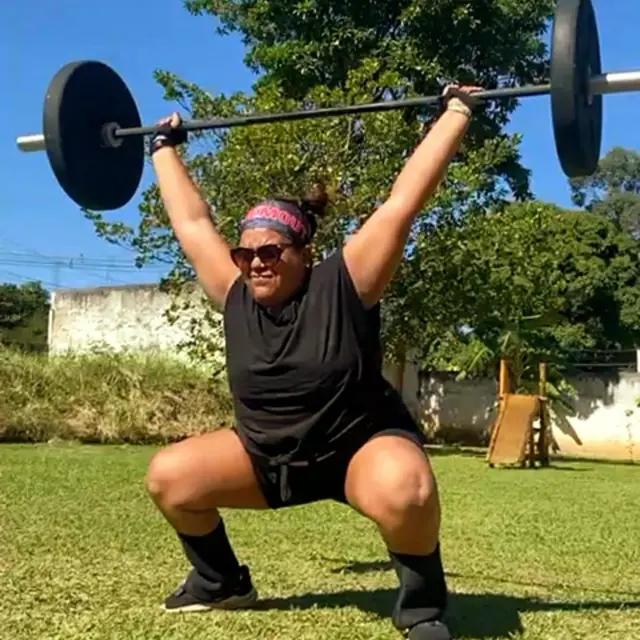 Cinthya Albuquerque levantando peso em área externa 