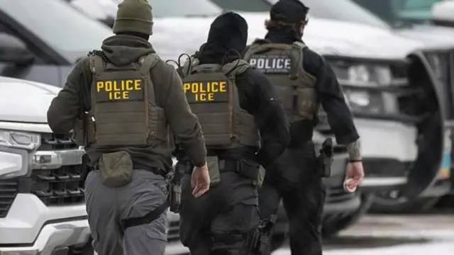 ثلاثة عناصر من إدارة الجمارك والهجرة الأمريكيون يسيرون في شارع