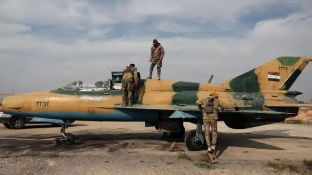 या फोटोत हमा शहरातील बंडखोर कोणत्याही लढाई शिवाय सैनिकांच्या लढाऊ विमानांचा ताबा घेताना दिसत आहेत.