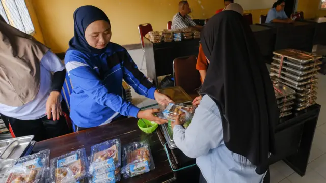 Kader keluarga berencana memberikan porsi Makan Bergizi Gratis (MBG) ke ibu hamil di Balai Desa Puosu Jaya, Kabupaten Konawe Selatan, Sulawesi Tenggara, Jumat (23/1/2026).