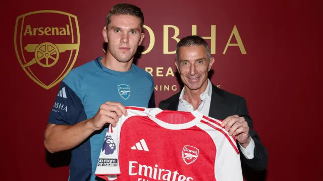 Viktor Gyokeres, Arsenal'e imza attıktan sonra spor direktörü Andrea Berta ile birlikte ev sahibi formasıyla poz veriyor