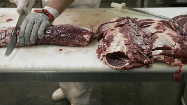 Carnicero cortando carne