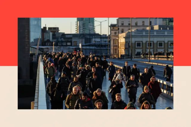 A crowd of people cross London Bridge 