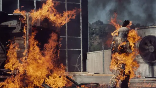 Kitty O'Neill camina por un lote envuelto en llamas durante una de sus acrobacias.