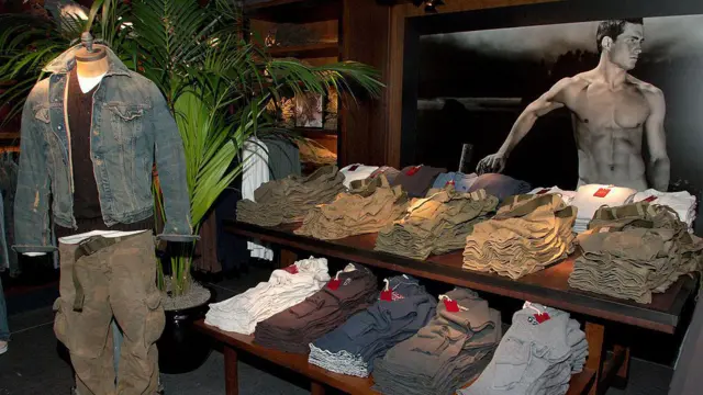 
Uma foto do interior da loja Abercrombie & Fitch na 5ª Avenidabets 96Nova York, tirada no eventobets 96inauguraçãobets 962005, mostrando pilhasbets 96roupas dobradas, um manequim vestido com uma jaquetabets 96jeans e calças cargo, e uma imagem publicitáriabets 96um modelo sem camisa ao fundo.