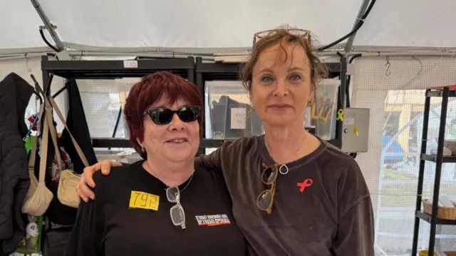 تالی (چپ) از آغاز جنگ به خانوادههای گروگانها کمک کرده است