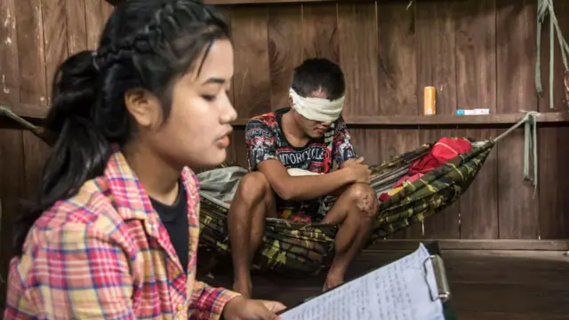 Free Burma Rangers (FBR) အဖွဲ့မှ အမျိုးသမီးဆေးတပ်သားတစ်ဦးက မျက်လုံးကိုပတ်တီးစီးထားရတဲ့ အမြင်အာရုံချို့တဲ့နေသူတစ်ဦးကို စာဖတ်ပြနေတဲ့ မြင်ကွင်းတစ်ခု။
၂၀၂၁ ခုနှစ်က ကရင်ပြည်နယ်ထဲမှာရိုက်ကူးထားတာဖြစ်ပါတယ်။
