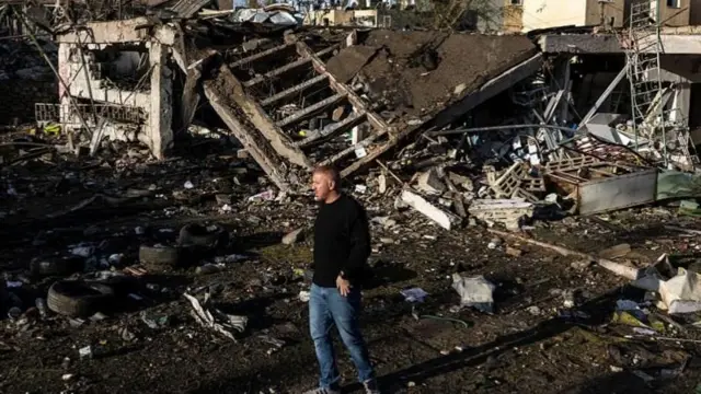 दक्षिणी शहर डिमोना में ईरानी मिसाइल हमले के बाद रविवार सुबह घटनास्थल पर मौजूद एक शख़्स