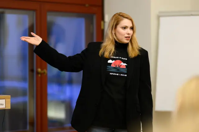 Марія Кутнякова у чорному жакет і чорні футболці