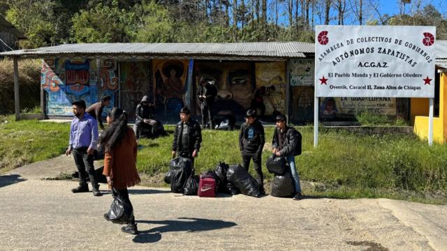 Niños esperan el transporte en una caseta.