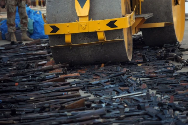 कराची के गिरोहों पर कार्रवाई में मिले हथियारों को तोड़ता बुलडोजर