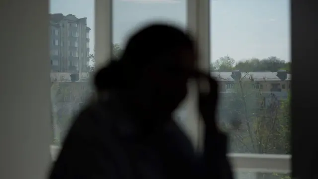 Екатерина — мама погибшего Ореста. Темный силуэт женщины напротив окна