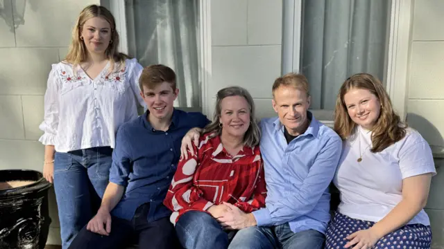 La familia Scolyer se sienta y posa para una foto.