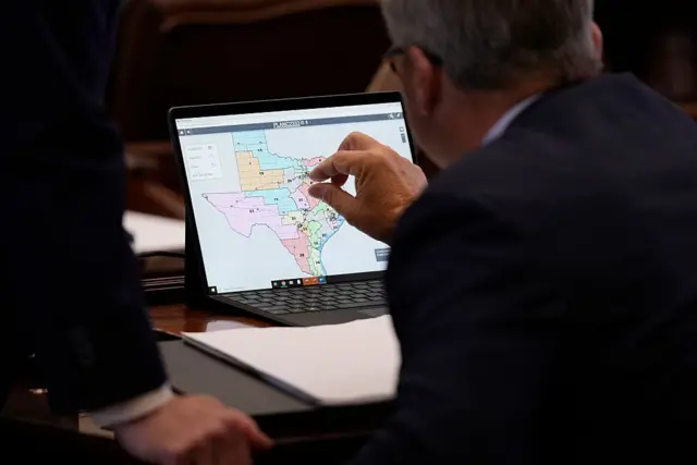 Uma pessoa em frente a um computador olhado para limites de um mapa