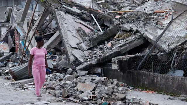 Una mujer camina frente a un edificio destruido por el terremoto en Quibdó, Colombia, el 12 de agosto de 2026