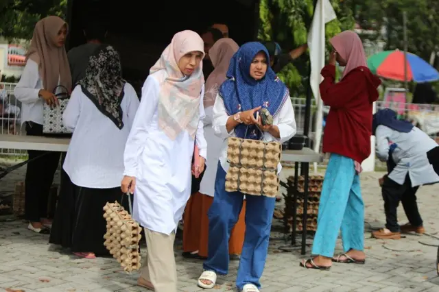Sejumlah warga antre membeli telur ayam saat berlangsung operasi pasar di Pasar Tani Banda Aceh, Aceh, Rabu (23/04).