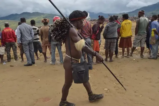 Seorang warga suku Dani berjalan melintasi kerumunan di sela-sela Festival di lembah Baliem di Distrik Walesi, Wamena, Provinsi Papua Province, Agustus 2016 lalu.