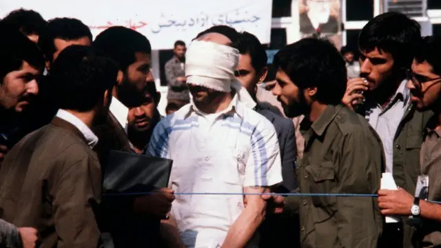 Blindfolded hostage among group of men