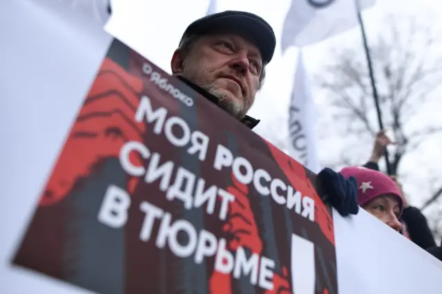 29 февраля 2020 года, Григорий Явлинский держит плакат с надписью «Моя Россия сидит в тюрьме», на марше памяти убитого Бориса Немцова в центре Москвы 