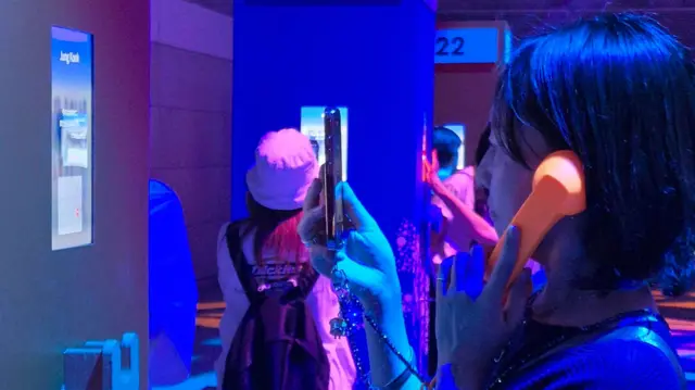 BTS 페스타에서 멤버들의 목소리를 수화기로 듣고 있는 팬