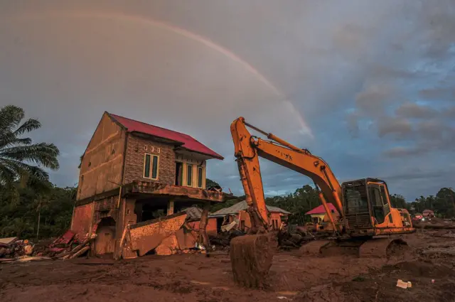 Sebuah alat berat terparkir di samping bangunan yang terdampak banjir bandang di Jorong Kayu Pasak, Nagari Salareh Aia, Palembayan, Agam, Sumatera Barat, Kamis (4/12/2025).