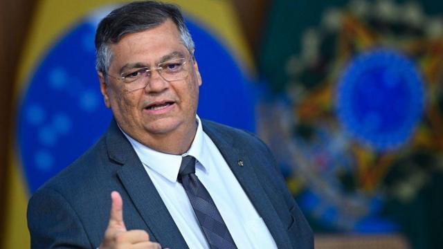 Dino gesticulando enquanto falacomo funciona aposta de jogo de futebolfrente a bandeiras