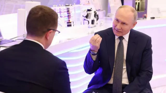 Журналист берет интервью у президента России. Путин что-то объясняет, жестикулируя