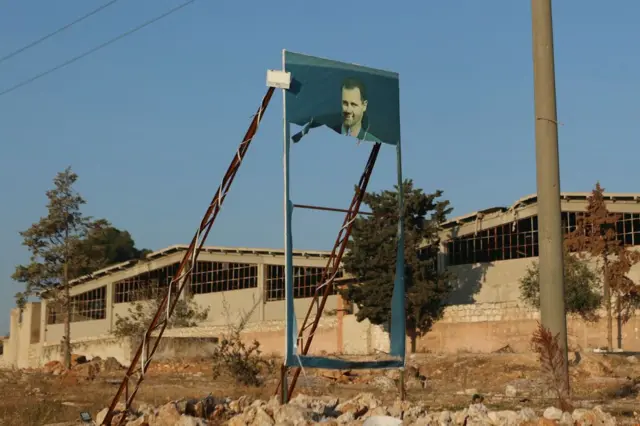 بنر بشار اسد در یک خیابان که مخالفانش پاره کرده‌اند