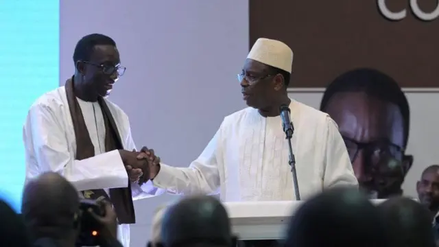 Le président sénégalais Macky Sall (C) serre la main du Premier ministre Amadou Ba à Dakar, le 21 décembre 2023, après que ce dernier a été désigné comme candidat du parti au pouvoir en vue de l'élection présidentielle de février 2024.