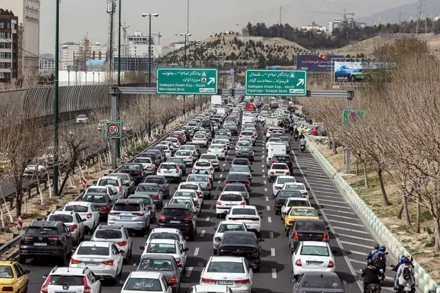 Para pengendara mobil melintas di sebuah jalan di Teheran pada Sabtu (28/02).