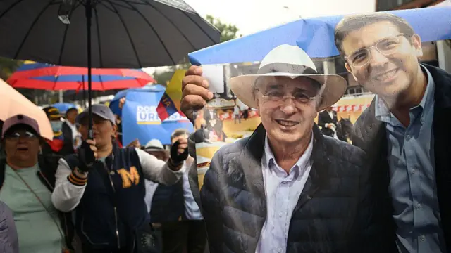 Carteles de apoyo a Miguel Uribe y Álvaro Uribe en una marcha reciente en Bogotá.