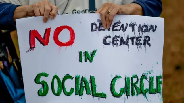 Un participante sostiene un cartel que dice "NO al centro de detención en Social Circle", durante una manifestación contra el centro de detención propuesto por el Servicio de Inmigración y Control de Aduanas de Estados Unidos.