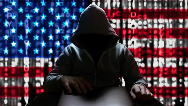 Un hacker con la bandera de EE.UU. de fondo