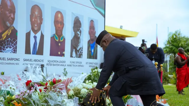 Sierra Leone president Julius Maada Bio lay flowers at the ceremonial garden of the presidency in memory of the deceased citizens. In the background na media pipo and a man wey dey play dirge from di flute for sympathizers 