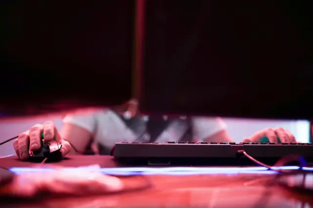 صورة تعبيرية لشخص يستخدم جهاز الحاسوب