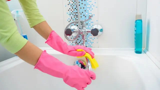 Una personan limpiando una bañera