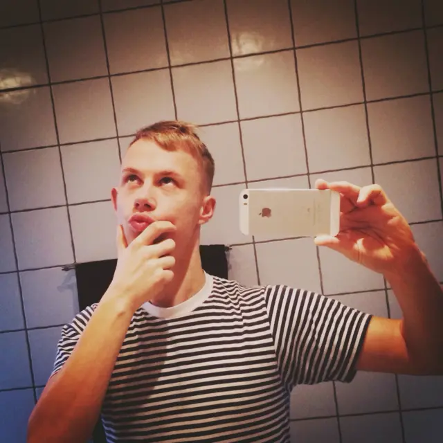 ผู้ชายถ่ายรูปเซลฟี่ในห้องน้ำ