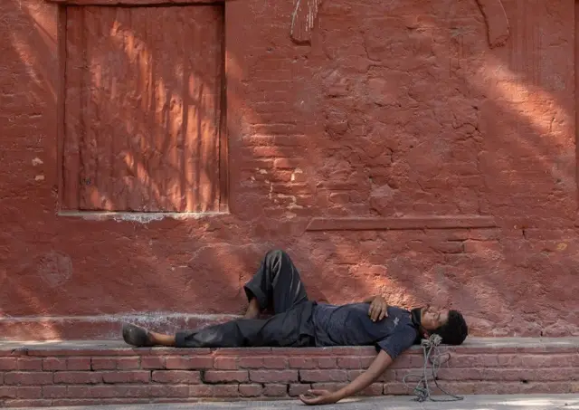 काठमाण्डूमा गर्मी बढ्दा छायामा आराम गर्दै एक श्रमिक