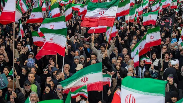9 मार्च को तेहरान में प्रदर्शनकारी ईरान के राष्ट्रीय ध्वज के साथ मोजतबा ख़ामेनेई के समर्थन में इकट्ठा हुए