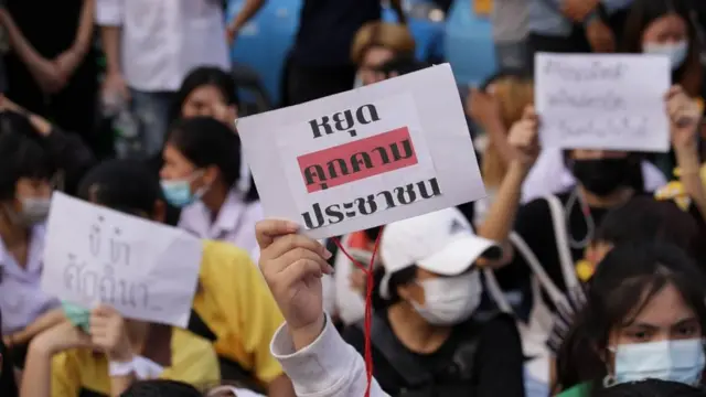 เยาวชนถือป้าย "หยุดคุกคามประชาชน"